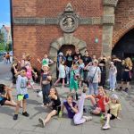 Grupa około 30 dzieci na tle Wieży więziennej o Katowni w Gdańsku